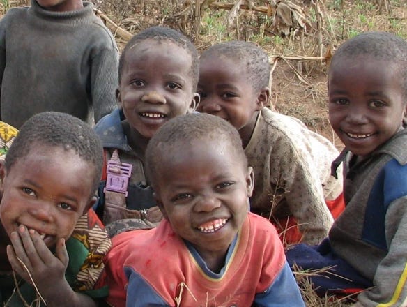 Young children from the Foxes Project, smiling and giggling